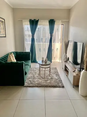 a living room with a green couch and a table at Ladybug unit 3 (2) in Midrand