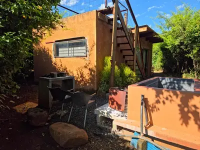 a backyard with a house and chairs and a pool at Hartbeest Bush Stay #4 in Hartbeespoort