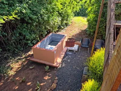 a large tub sitting in the dirt in a garden at Hartbeest Bush Stay #4 in Hartbeespoort
