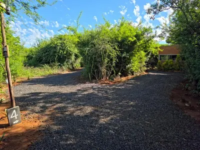 an empty road with trees and a building at Hartbeest Bush Stay #4 in Hartbeespoort