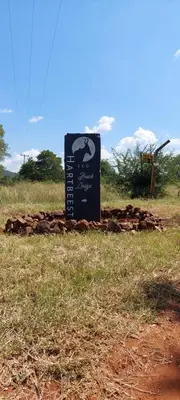 a sign sitting in the middle of a field at Hartbeest Bush Stay #4 in Hartbeespoort