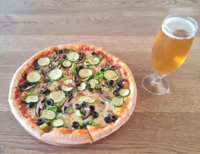 a pizza on a table next to a glass of beer at Vacation at the Blyde Riverwalk Estate in Pretoria