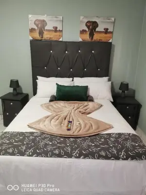 a bed with a large wooden blanket on it at A home away from Home in Musina