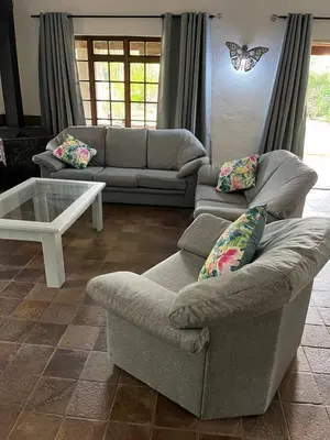 a living room with two couches and a butterfly on the wall at Mi Casita in Graskop