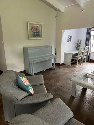 a living room with a couch and a piano at Mi Casita in Graskop