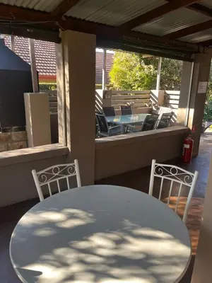a table and chairs on a porch with a table and chairs at Mi Casita in Graskop