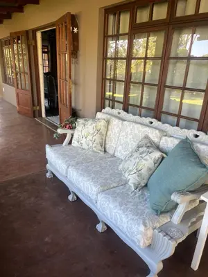 a white couch sitting in a room with windows at Mi Casita in Graskop