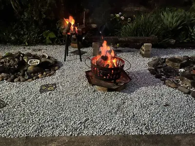 a fire pit with flames in a gravel yard at Mi Casita in Graskop