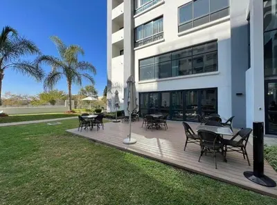 a deck with tables and chairs in front of a building at Luxurious Resorts in Pretoria