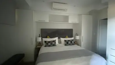 a bedroom with a white bed with black and white pillows at Luxurious Resorts in Pretoria