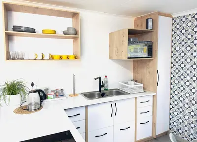 a kitchen with white cabinets and a sink at Lemon Ivy Guesthouse in Polokwane