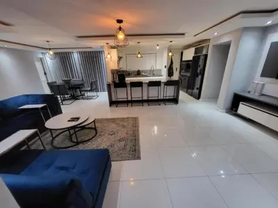 a living room with a blue couch and a kitchen at DZUVHA BOUTIQUE VILLA in Hartbeespoort