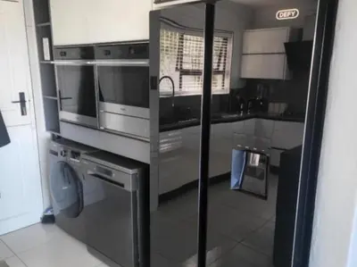 a kitchen with a stainless steel refrigerator and a dishwasher at DZUVHA BOUTIQUE VILLA in Hartbeespoort