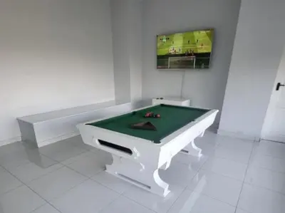 a pool table in a white room with a tv at DZUVHA BOUTIQUE VILLA in Hartbeespoort