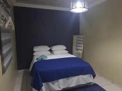a bedroom with a bed with a blue blanket at Queen Light in Pretoria