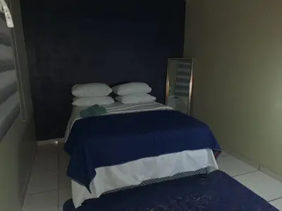 a small bed with blue and white sheets and pillows at Queen Light in Pretoria