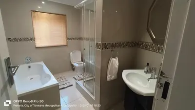 a bathroom with a sink and a shower and a toilet at Trumma Guest House in Pretoria
