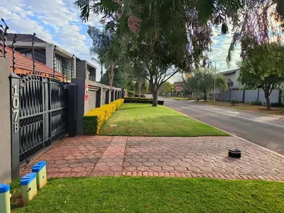 a brick walkway next to a house with a fence at Trumma Guest House in Pretoria