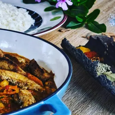 a bowl of food and rice on a wooden table at Woodpecker Villa Guesthouse in Thabazimbi