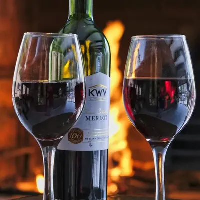 two glasses of red wine next to a bottle of wine at Woodpecker Villa Guesthouse in Thabazimbi