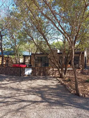 a house with a tree in front of it at Woodpecker Villa Guesthouse in Thabazimbi
