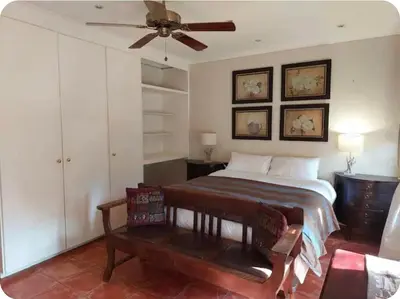 a bedroom with a bed and a ceiling fan at Khalila's Equestrian Cottage in Midrand