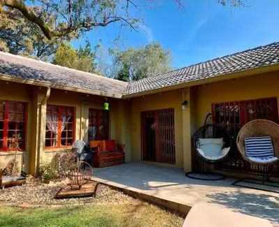 a house with a porch with a patio at Khalila's Equestrian Cottage in Midrand