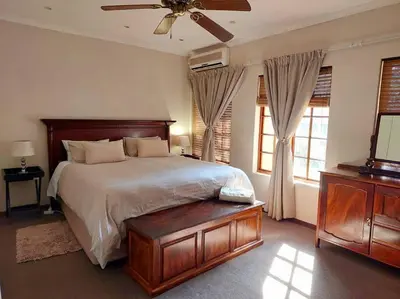 a bedroom with a bed and a ceiling fan at Khalila's Equestrian Cottage in Midrand