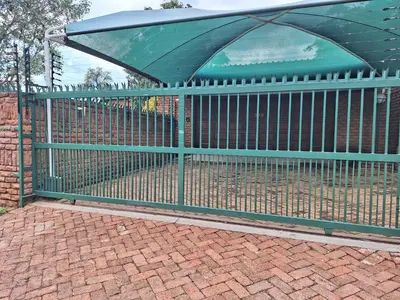 a green metal fence with a canopy on top of it at Emani Guest House in Mokopane