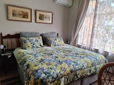 a bedroom with a bed with a colorful comforter and a window at Emani Guest House in Mokopane