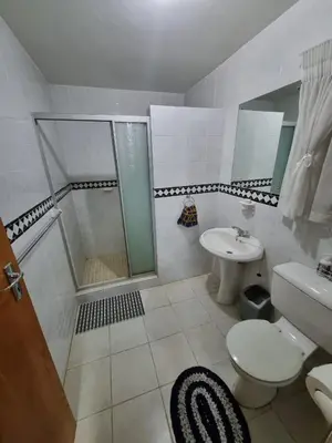 a bathroom with a shower and a toilet and a sink at Emani Guest House in Mokopane