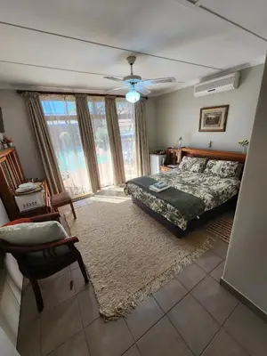 a bedroom with a bed and a large window at Emani Guest House in Mokopane