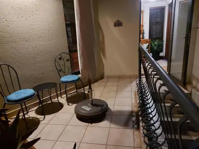 a room with two chairs and a table and a wheel at Bella's Place in Pretoria