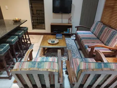 a living room with a couch and chairs and a table at Bella's Place in Pretoria