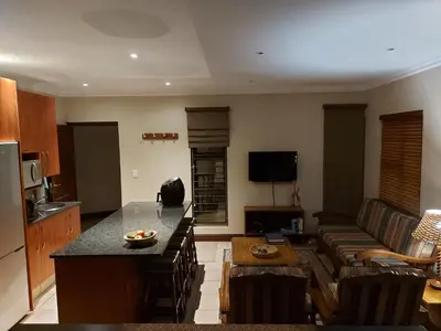 a kitchen and living room with a couch and a table at Bella's Place in Pretoria