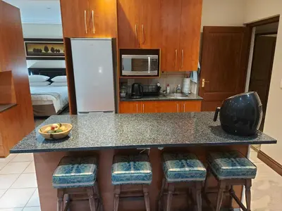 a kitchen with a counter and some bar stools at Bella's Place in Pretoria