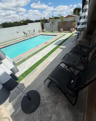 a swimming pool with a table and chairs next to it at The Pool_deck apartment in Lebowakgomo