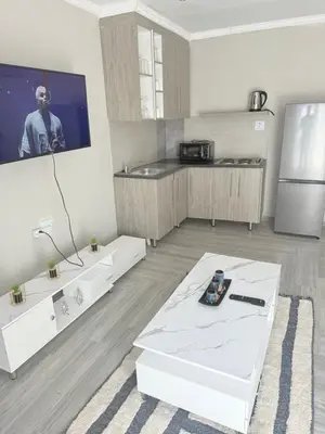 a kitchen with a white table and a refrigerator at The Pool_deck apartment in Lebowakgomo