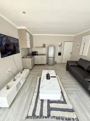 a living room with a couch and a table at The Pool_deck apartment in Lebowakgomo