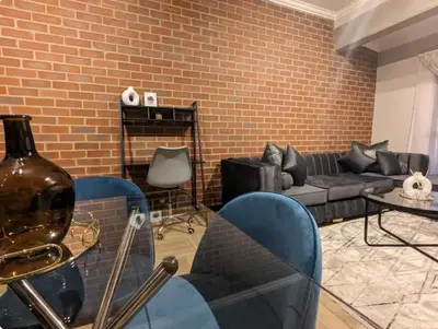 a living room with a couch and a brick wall at Spacious 2 Bedroom Apartment in Midrand, Waterfall City - Business and Family friendly - 1 Elizabeth Place in Midrand