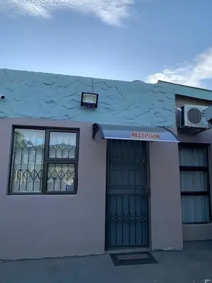 a white building with a door and a window at Mudix Royal Palace Guest Lodge in Musina