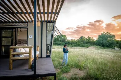 a person standing on the porch of a house at Kamoka Camp in Hoedspruit