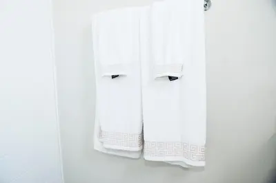 a group of white towels hanging on a wall at Eirini Elegant - Artemis Apartment Carlswald in Midrand