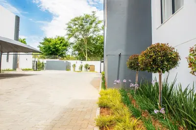 a brick courtyard with flowers and a building at Eirini Elegant - Artemis Apartment Carlswald in Midrand