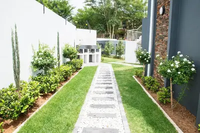 a garden with grass and a walkway at Eirini Elegant - Artemis Apartment Carlswald in Midrand
