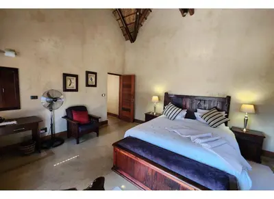 a bedroom with a bed and a desk and a chair at Zebula Bush Lodge 118 in Mabula