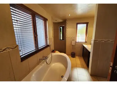 a bathroom with a bath tub and a sink at Zebula Bush Lodge 118 in Mabula