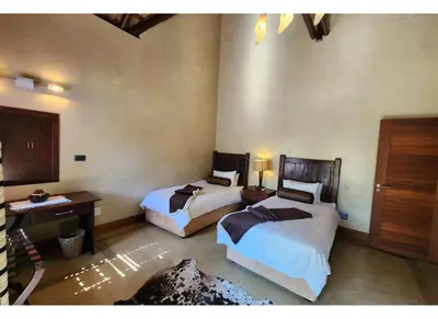 a bedroom with two beds and a desk and a sink at Zebula Bush Lodge 118 in Mabula