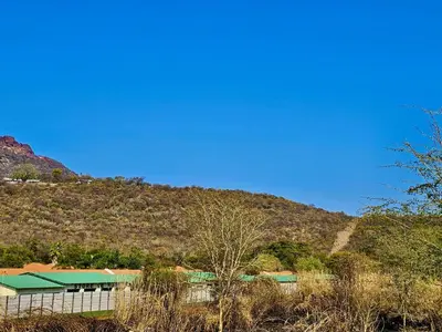 a building with a mountain in the background at Valozone70 Guesthouse in Thabazimbi