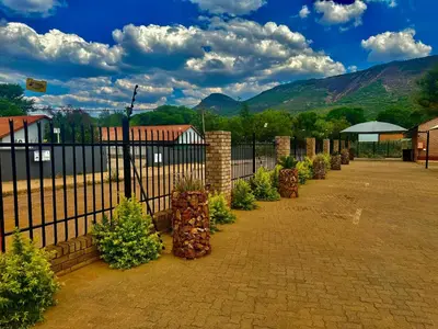 a fence with a bunch of plants in a yard at Valozone70 Guesthouse in Thabazimbi